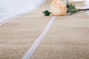 Corsia da tavola in juta con pizzo bianco, dettaglio rustico ideale per feste e matrimoni.