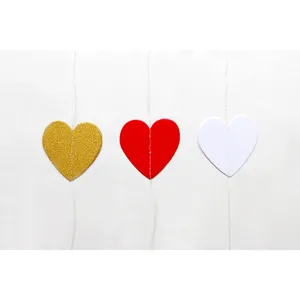 Heart garland detail showing gold, red, and white paper hearts connected by string for parties.