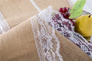 Primo piano dettaglio del runner da tavola in juta rustica con delicato pizzo bianco fine.