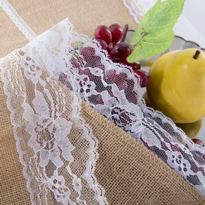 Cammino da tavola in juta rustica con bordo in pizzo bianco per feste e matrimoni.