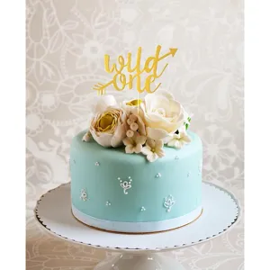 Gold glitter wild one cake topper detail close up view with floral cake decoration