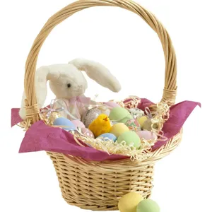 Panier en osier de Pâques avec lapin en peluche, poussin jaune et œufs décoratifs.
