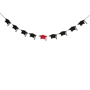 Close up of graduation cap banner details, black and red caps hanging on string for party decor.