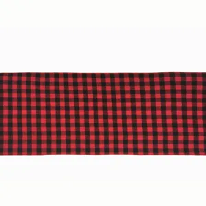 Dettaglio runner da tavola a quadri rosso e nero, design in tessuto scozzese classico per decoro.