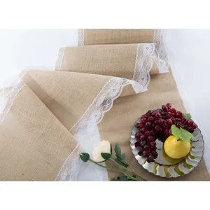 Rustic burlap table runner with delicate white lace trim for wedding party and home decor.