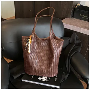 Detailed view of women's dark brown woven leather tote shoulder bag, vintage autumn style.