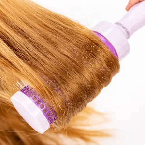 Brosse rouleau coiffante rose pour des boucles lisses et des soins capillaires à la maison.