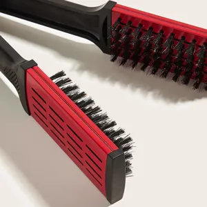 V-shaped hair straightening brush clamp with bristles and ventilation slots for styling.