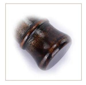 Gros plan du manche de blaireau de rasage en bois vintage, montrant une texture et un design.