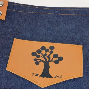 Λεπτομερης οψη για ποδια εργασιας απο denim υφασμα με δερματικη τσεπη και δενδρο.