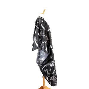 Professional black barber cape for hair cutting and styling with tools pattern on mannequin