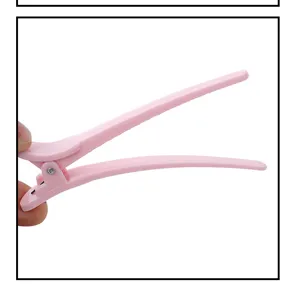 Pink hair sectioning clip detail view, durable plastic duckbill styling clamp for salon use.