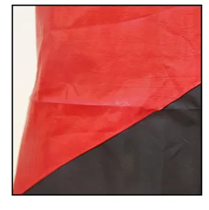 Close-up fabric detail of hairdressing cape showing red and black color block textile.