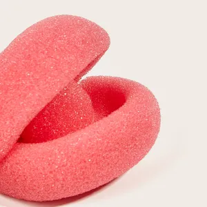 Gros plan détaillé du rouleau à cheveux en mousse rose pour un coiffage sans chaleur.