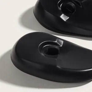 Black silicone hair dye ear covers detail shot, waterproof protective ear caps for salon styling.