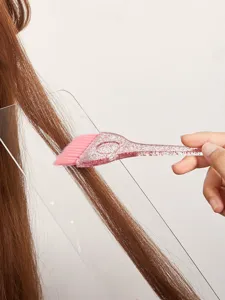Gros plan sur la brosse à teinture rose pailletée avec manche transparent et poils.