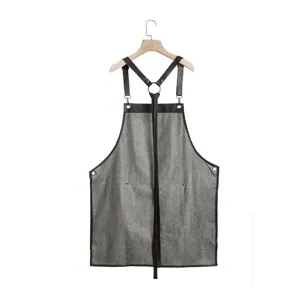 Adjustable strap denim work apron for hair salon, stylish hairdresser styling utility apparel.