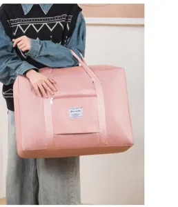 Grand sac de voyage pliable, sac de rangement et bandoulière rose pour bagages et déménagement.