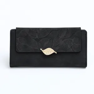 Close-up of black matte long wallet with leaf pattern flap and golden leaf clasp detail.