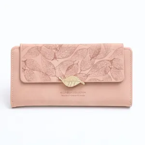 Closeup of pink matte long women wallet with leaf print and golden metal leaf buckle detail.