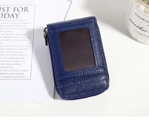 Close-up detail of blue mini litchi pattern card holder featuring zipper and clear window.