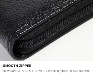 Close-up detail view of black leather wallet zipper, showing smooth texture and stitching.