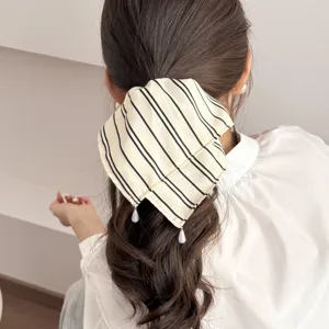 Detail view of a Korean minimalist striped fabric hair scrunchie with cute hanging pearls.