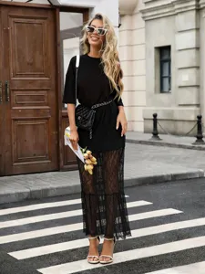 Detailed view of the stylish women's black dress featuring short sleeves and sheer lace lower panels.