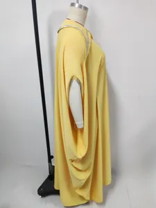 Gedetailleerd overzicht van de elegante gele maxi-jurk met strass en vleermuismouwen.