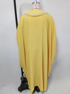 Detailweergave van een gele maxi-jurk met wijde mouwen en een schitterende strasskraag.