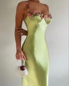 Detail view of the elegant sage green satin slip dress featuring 3D floral strap and bust details.