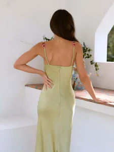 Green satin slip dress with floral strap, elegant backless design for summer chic party.