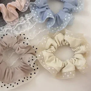 Detail shot of sweet fabric hair scrunchies with lace ruffles and cute polka dots for women.