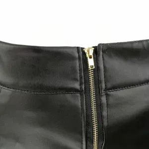 Close-up detail view of women black PU leather skirt featuring golden zipper waist design.