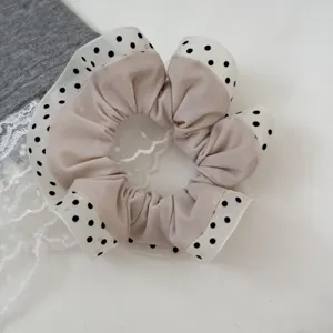 Detailed view of cream polka dot scrunchie with lace trim, sweet forest style hair accessory.