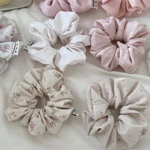 Detailed close-up of Korean style pink floral and polka dot hair scrunchies set.