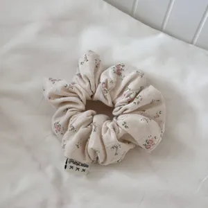 Detail of Korean style pink floral hair scrunchie, premium fabric with delicate print.