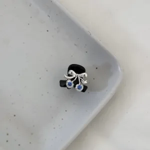 Mini black hair claw clip featuring a silver bow and blue rhinestone cherries for sweet style.