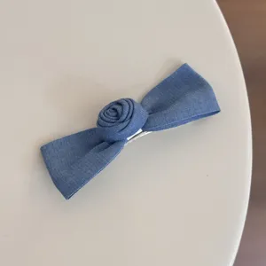 Detailed shot of the blue denim bow hair clip featuring a cute rose design for sweet styling.