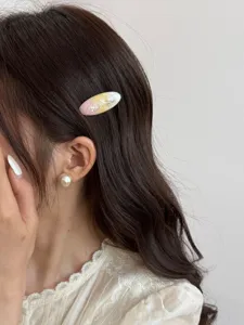 Close-up detail of the elegant oval hair clip featuring stunning gradient tone and delicate flakes.