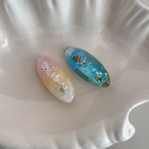 Resin hair clips detail featuring ocean shell and starfish design, elegant duckbill clip.
