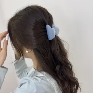 Gros plan d'une élégante pince à cheveux en forme de cœur bleu, style parfait.