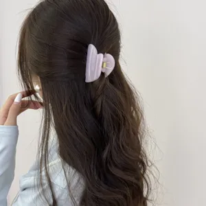 Vue détaillée de l'élégante pince à cheveux en forme de cœur mauve pastel pour un style chic.