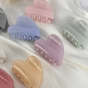 Vue détaillée de pinces à cheveux douces en forme de cœur aux couleurs pastel vibrantes.