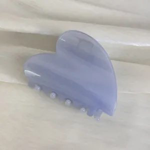 Détail de pince à cheveux cœur avec un beau matériau en résine brillante et élégante.