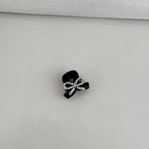 Detailed close-up view of the sweet rhinestone bow hair claw clip, delicate accessory.