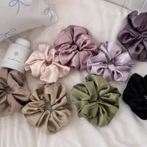 Detalle coleteros de saten, conjunto de cintas para el pelo de seda multicolor para peinados chic.
