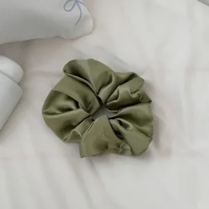 Coletero de pelo de satén verde oliva vista detallada, accesorio elegante para peinado diario.