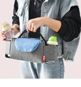 Stroller organizer bag with multiple compartments, grey fabric pram caddy for baby bottles and diapers.