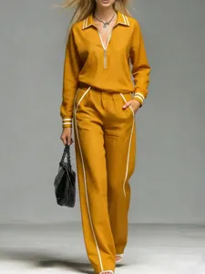 Detail shot of stylish mustard yellow tracksuit featuring zip collar and contrast stripes.